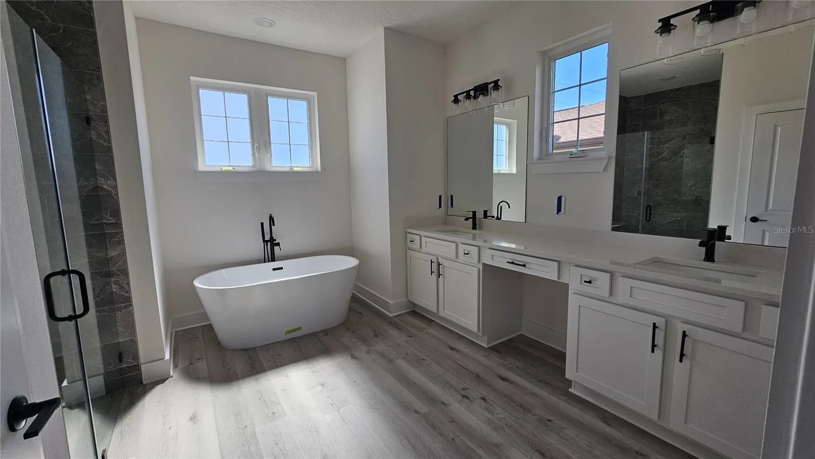 Baño principal con bañera independiente, ducha de vidrio y doble lavamanos